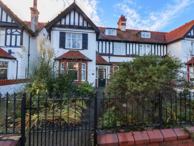 A building with a garden and fence at Southbourne Manor in Llandudno