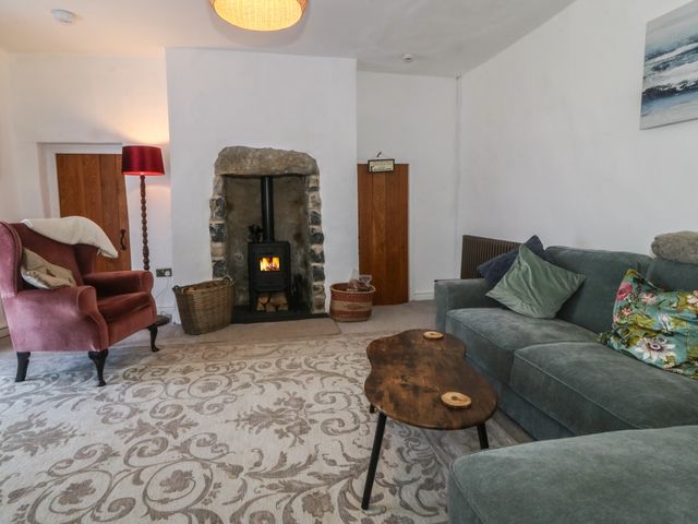 A living room with a sofa and an armchair at Tan Y Merddyn Ceunant near Llanrug