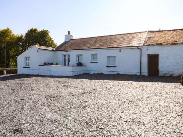 A house with a gravel area and trees at Tan Y Merddyn Ceunant near Llanrug