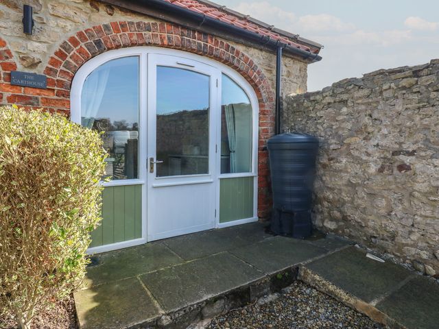 An outdoor area with a door and water tank at The Cart House Snape near Bedale