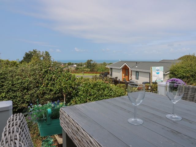 An outdoor area with a table and glasses at Coogee View in Maenygroes near New Quay