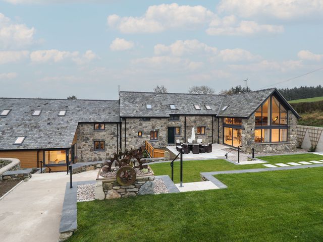An outdoor area with a house and patio furniture at Y Stabl in Cerrigydrudion