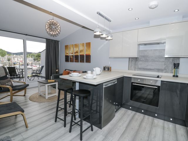 A kitchen with seating and a view at Harbwr Hideaway in Porthmadog