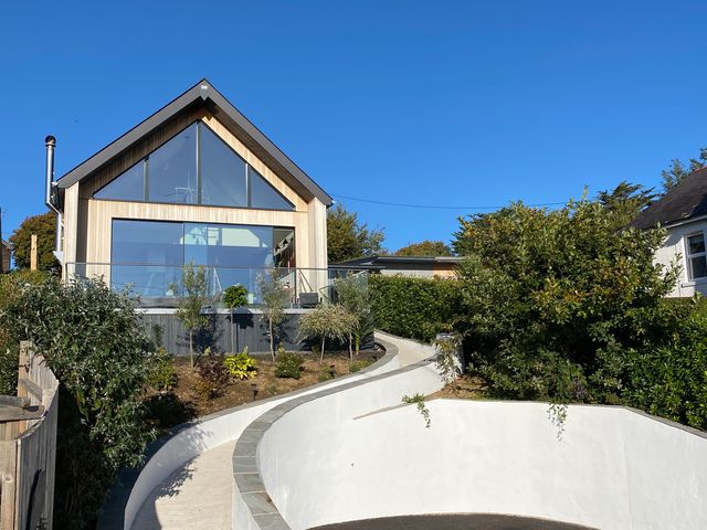 A house with large windows and a pathway at Woodcroft in Pwllheli