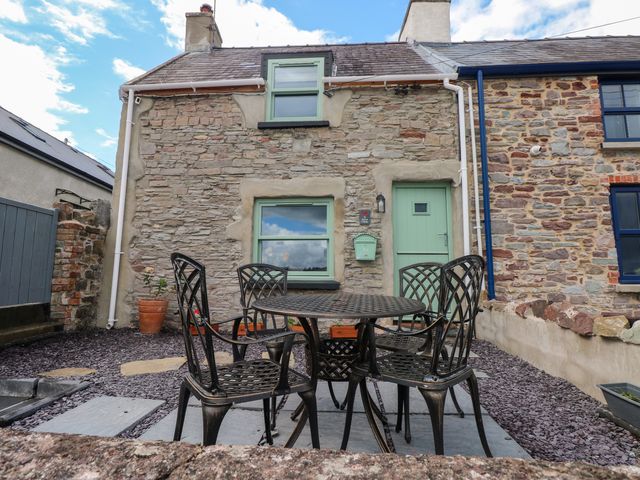 A garden with a table and chairs at 2 Strand Cottages in Laugharne