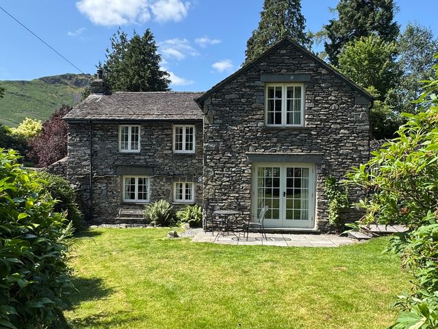A house with a garden and patio at Stone Arthur Cottage in Grasmere