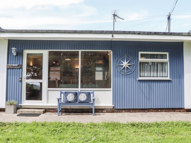 A house with a blue exterior and a bench at Driftwood in Dartmouth