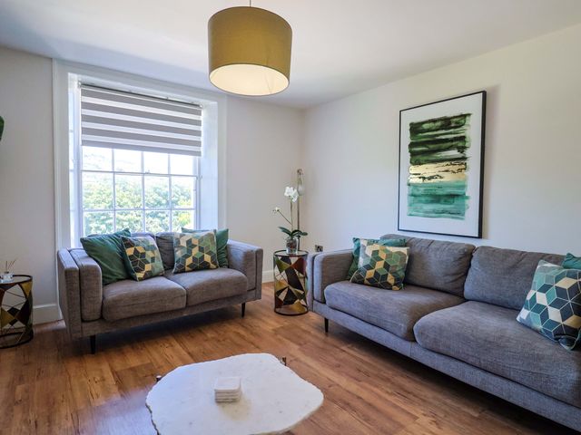 A living room with two sofas and a coffee table at Pebble Cove in Lyme Regis