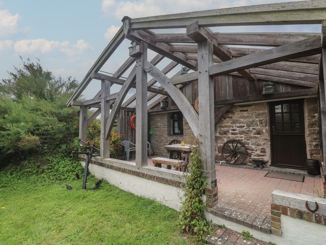 An outdoor area with a table and chairs at Horseshoe Cottage near Holywell Bay