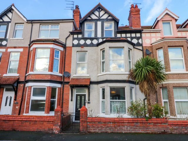 A house with multiple windows and a palm tree at Curzon Heights in Llandudno