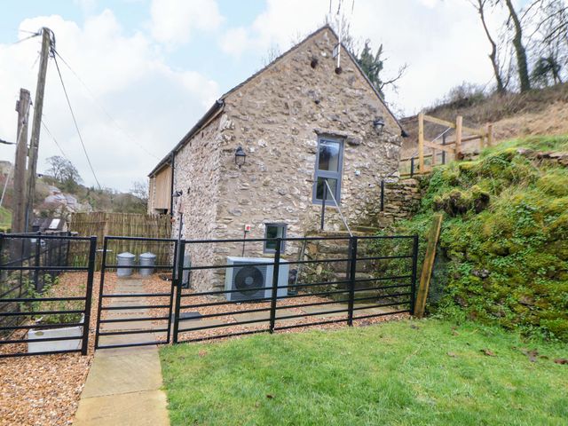 An outdoor area with a stone house and fenced gravel path at Horsedale Barn in Bonsall