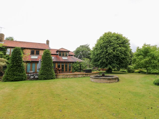 A garden with a house and fountain at The Old Mill House in Cuckney