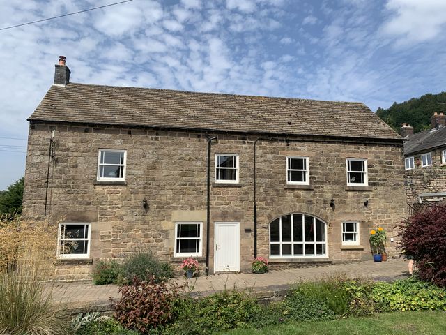 A stone house with windows and a front door at The Coach House in Holloway
