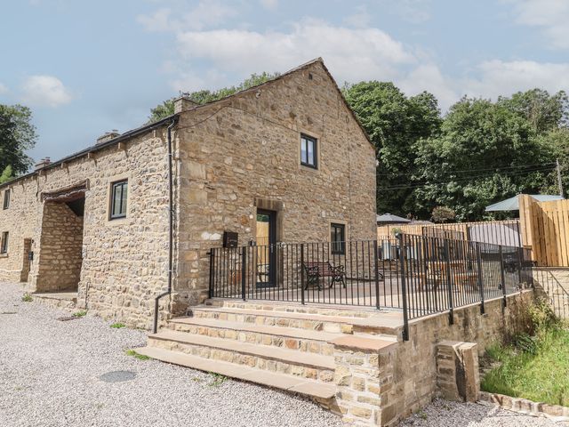 A house with stone walls and a patio at Virginia Cottage Winterburn