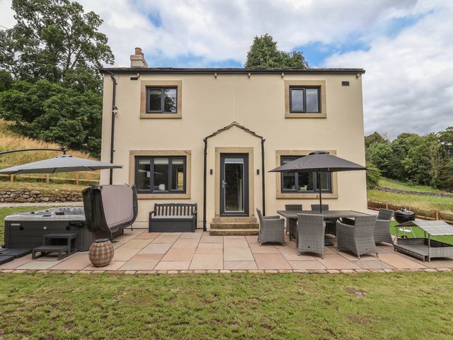 An outdoor area with a patio and furniture at Wood Cottage in Winterburn
