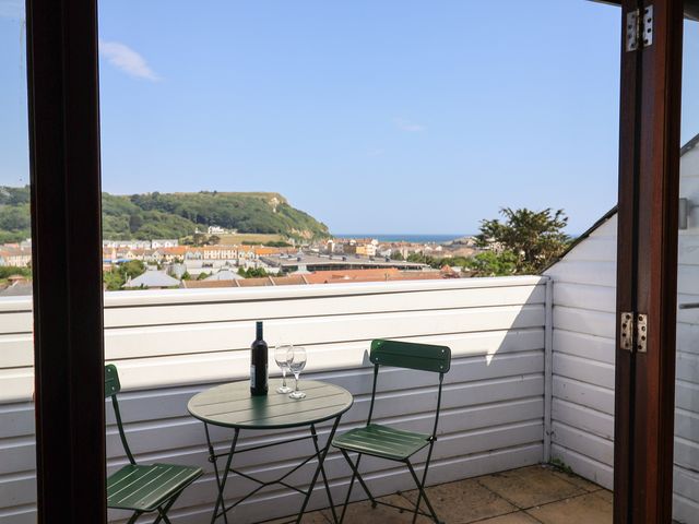 A balcony with a table and chairs at Cliff View in Seaton