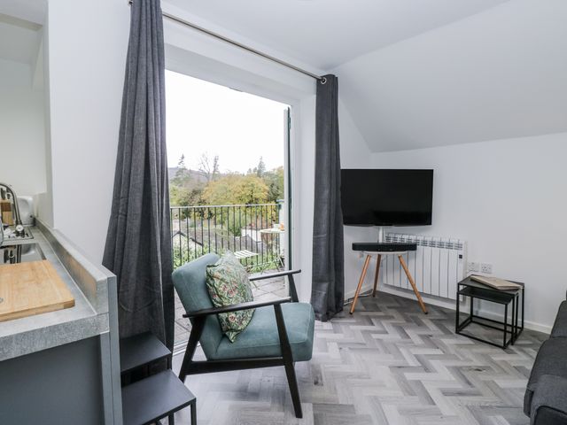 A living room with a television and sofa at Claife Flights in Bowness-On-Windermere