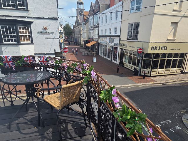 A terrace with table and chair overlooking a street at Harbour Retreat in Weymouth