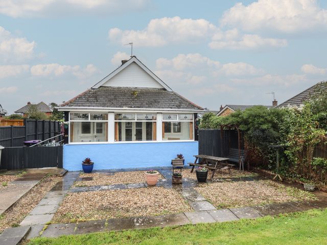 A garden with a bungalow and gravel area at Orby Cottage in Chapel St Leonards