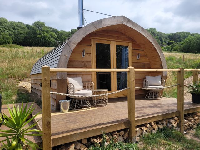 A log cabin with a deck and chairs at Holbein in Matlock