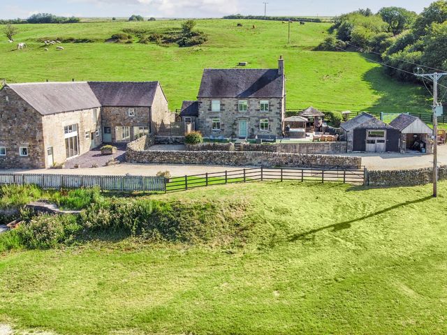 An exterior view of a farmhouse and outbuilding at Parlour Barn in Leek