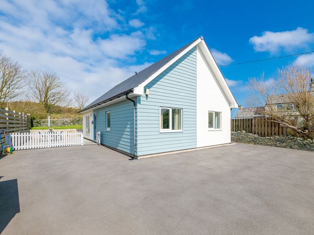 A house with a driveway and a fence at Moranedd Bach in Holyhead