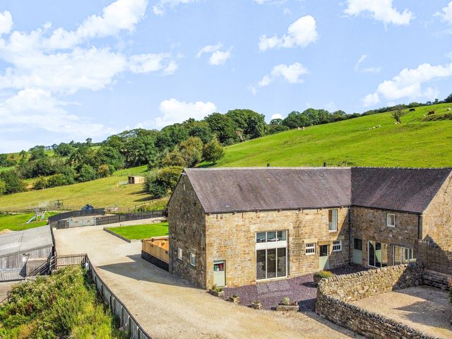 A barn with surrounding land and trees at Pastures Barn in Bradnop near Leek
