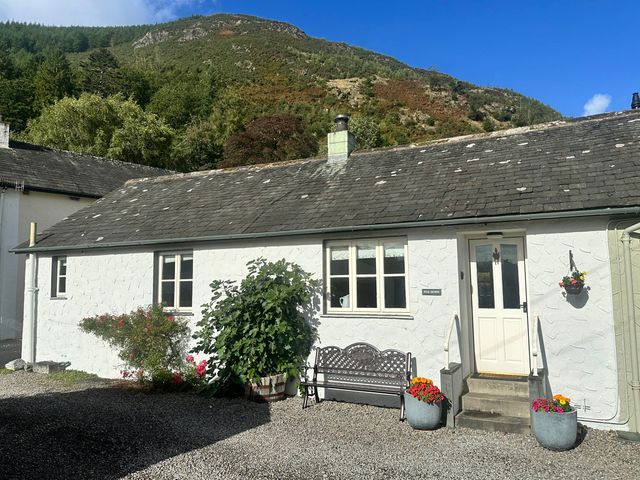 A house with a bench and flowers outside at Fox Howe in Thornthwaite