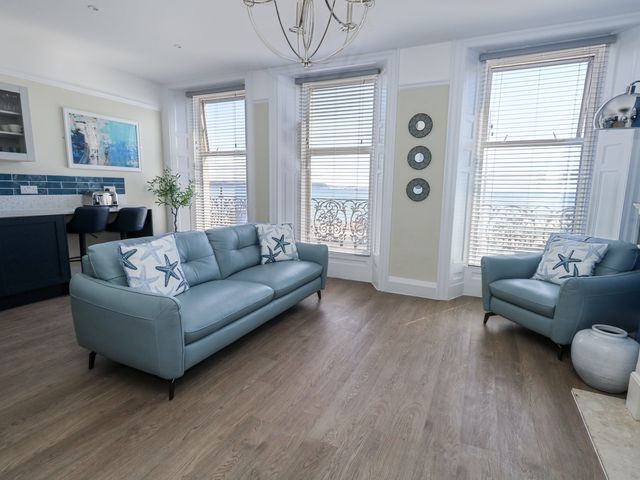 A living room with a sofa and armchair at Apartment 1 in Weymouth