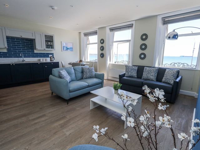 A living room with a coffee table and sofas at Apartment 2 in Weymouth