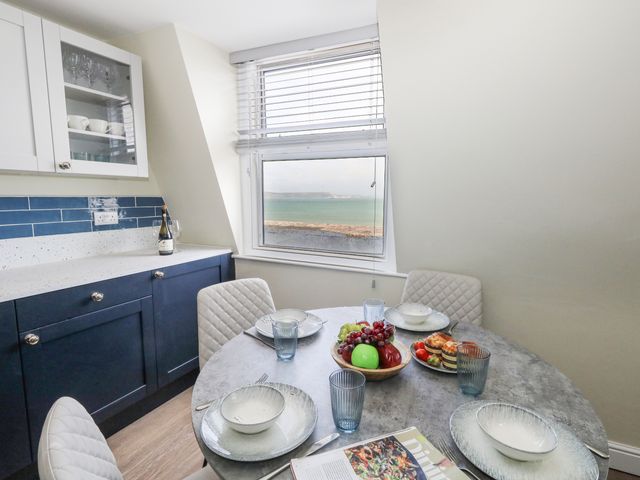 A kitchen with a dining table and chairs at Apartment 3 in Weymouth