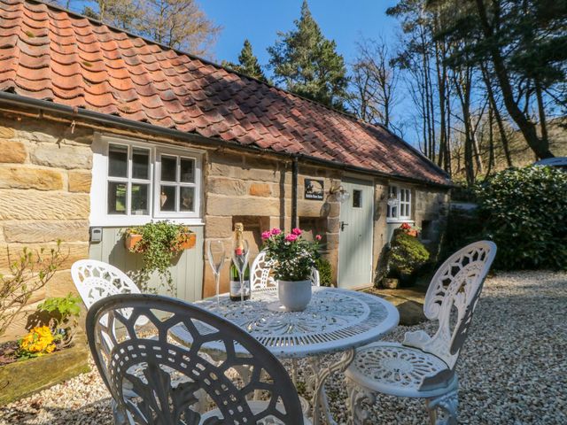 A table and chairs with flowers outside a cottage at Maltkiln House Annexe Chop Gate near Stokesley