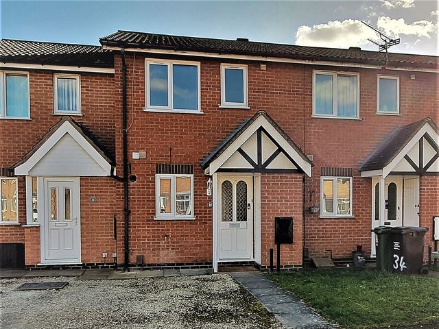 A brick house with front doors and a pathway at 32 Moorland House