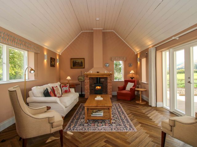 A living room with a sofa and fireplace at Hoddell Pitch Cottage, Kinnerton near New Radnor