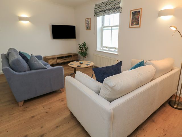 A living room with sofas and a television at Weyside in Weymouth