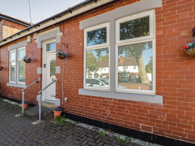 An entrance with brick wall and flower pots at Cosy Escape in Birmingham