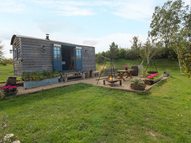 An outdoor area with a shepherd's hut and seating at Lillie's Shepherds Hut at Shepherds Lodge Retreat and Wellness Bottesford near Redmile and Vale of Belvoir