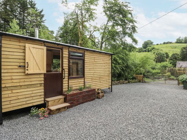 A wooden cabin with steps and gravel area at The Hamper in Felingwm near Carmarthen