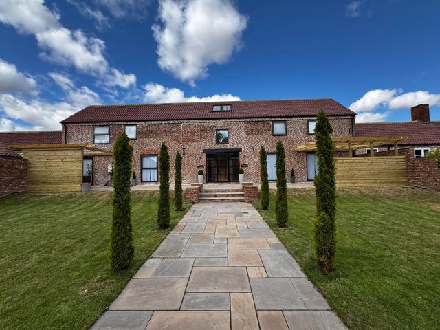 A house with a pathway and lawn at Courtenay House Harpham near Nafferton
