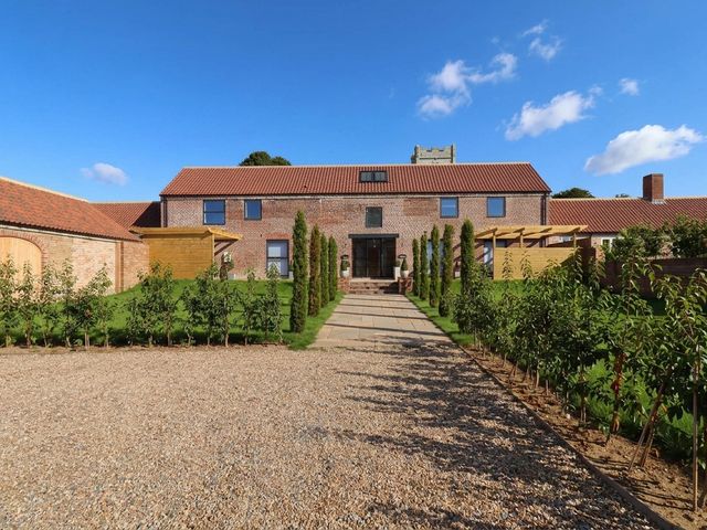 An outdoor view of a house with a pathway and garden at Courtenay House Harpham near Nafferton