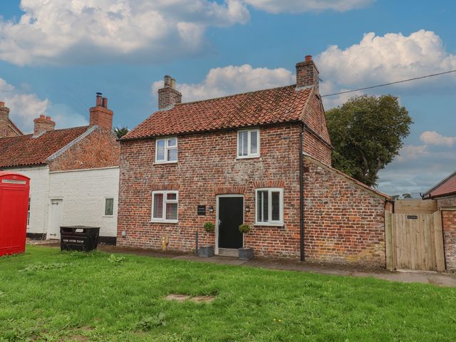 A house with a brick exterior and windows at Manor Cottage Harpham near Nafferton