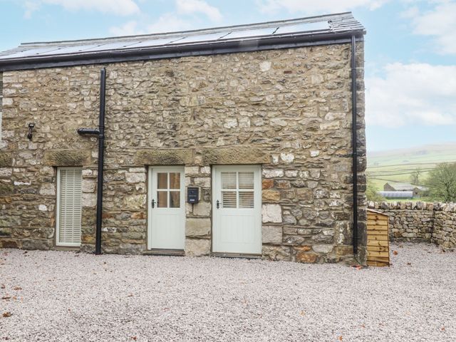 An outdoor area with stone walls and two doors at Henside Cottage in Settle