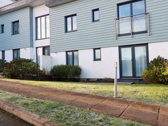 A modern residential building with grass and shrubs in front at Freesia Threemilestone near Truro