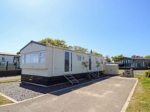 A mobile home with steps and planters at MillRythe Holiday Park (Dunlin Walk 13) Hayling Island