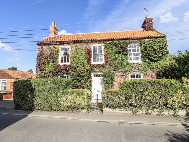A house with ivy on the facade and hedges in front at Holme Farm in Ruskington