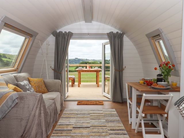 A living room with a sofa and table at Under Oak Pod in Totnes