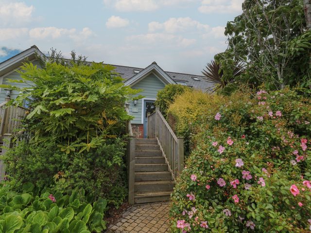 A pathway leading to a building with stairs surrounded by plants at 2 Court Cottage in Dartmouth