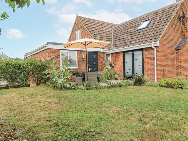 A garden with furniture and an umbrella at The West Wing in Potterne