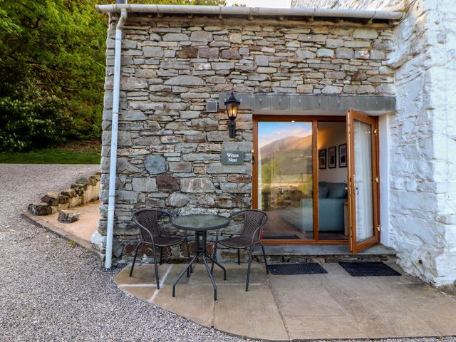 An outdoor area with a table and chairs at Wren's Nest Thornthwaite near Braithwaite