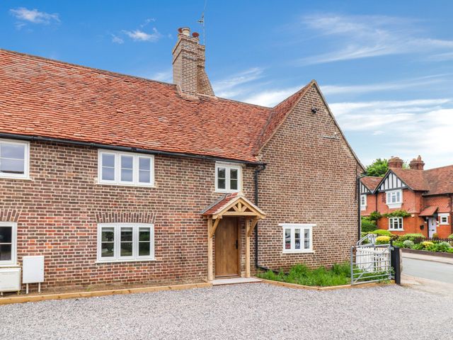 A house with a front door and gravel driveway at Tuffs Farm Cottage 1 in Kings Langley